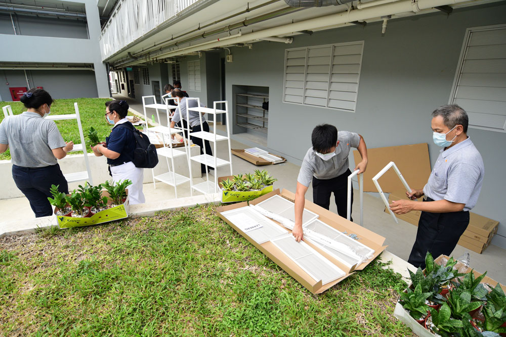 Tzu Chi staff and volunteers assembling bookshelves to be placed inside the dormitory. (Photo by Wong Twee Hee)  